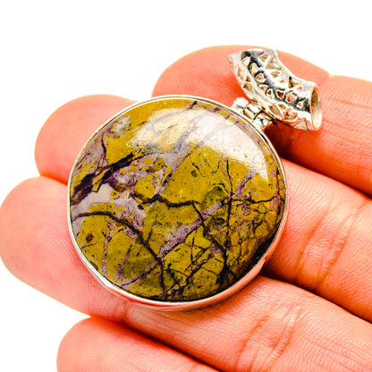 Round sterling silver pendant with yellow-purple stone cabochon and ornate bail