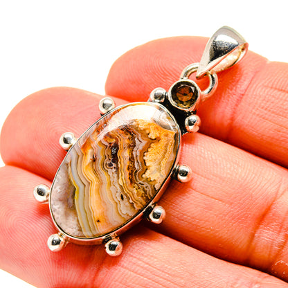 Sterling silver agate pendant with orange-brown banded stone and dark round top
