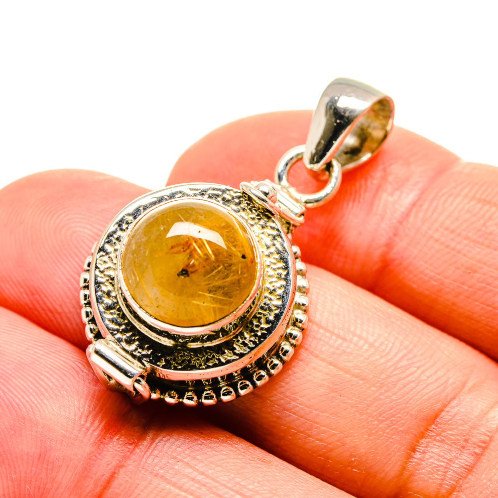 Sterling silver pendant on bail with round golden rutilated quartz cabochon on hand