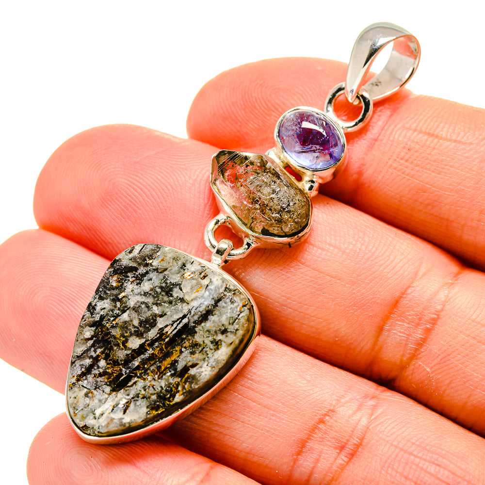 Silver pendant with rough yellow-green stone and round blue-violet accent in bezel setting