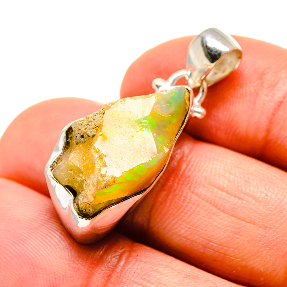 Rough Ethiopian opal pendant in sterling silver bezel with orange-green color play