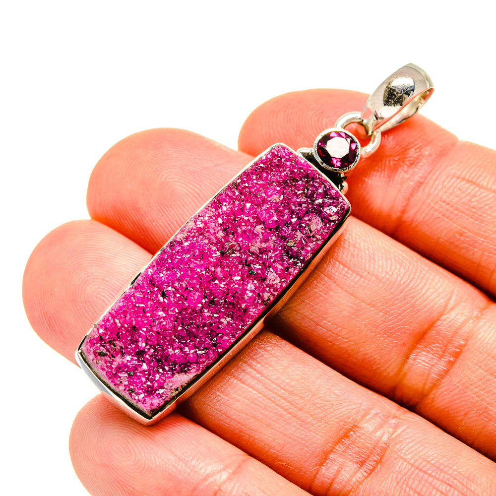 Silver-framed pink druzy rectangle pendant with round red stones on top bail