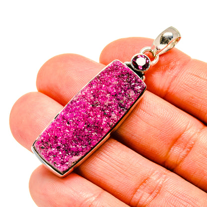 Silver-framed pink druzy rectangle pendant with round red stones on top bail