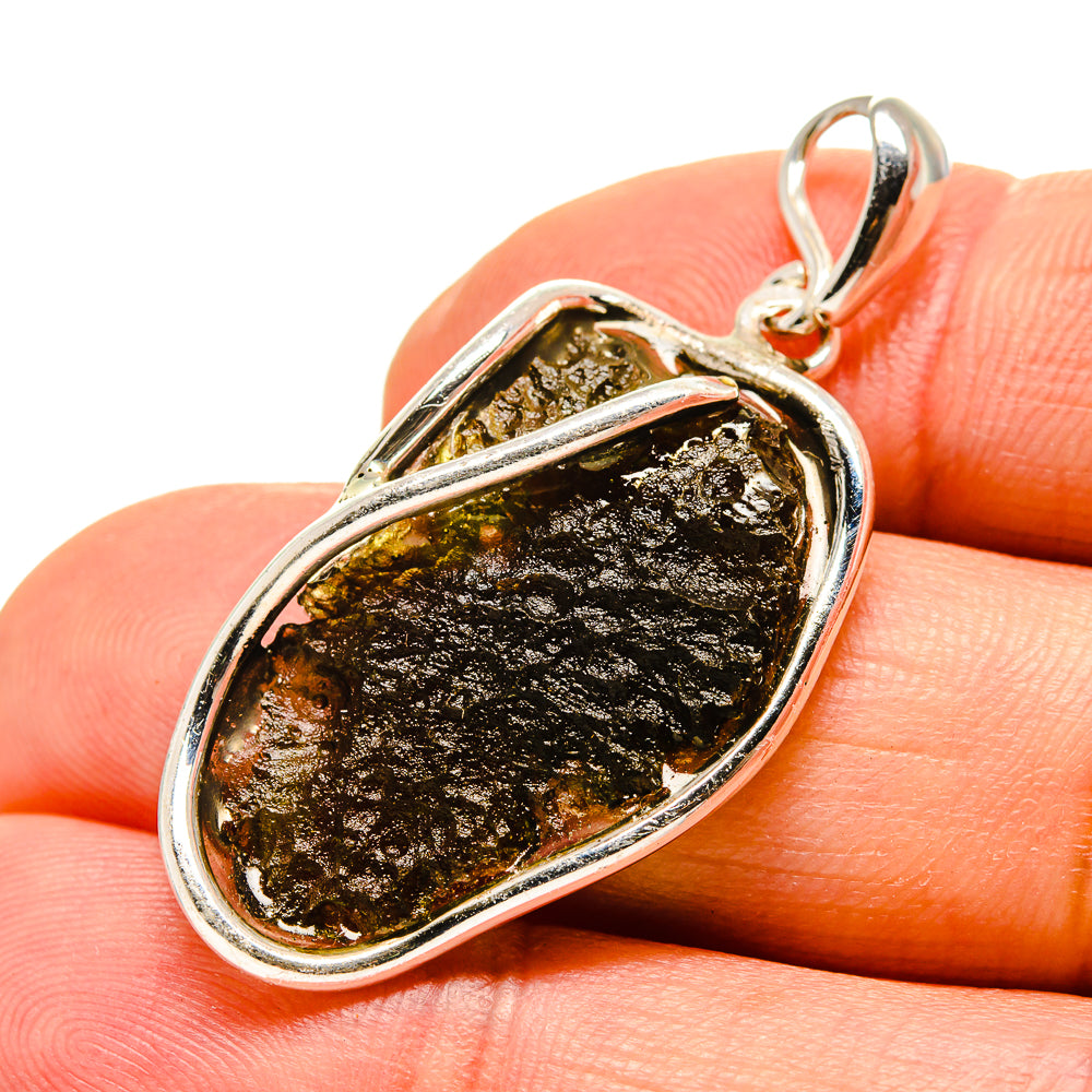 Sterling silver Moldavite pendant with dark brown to black rough stone in oval frame