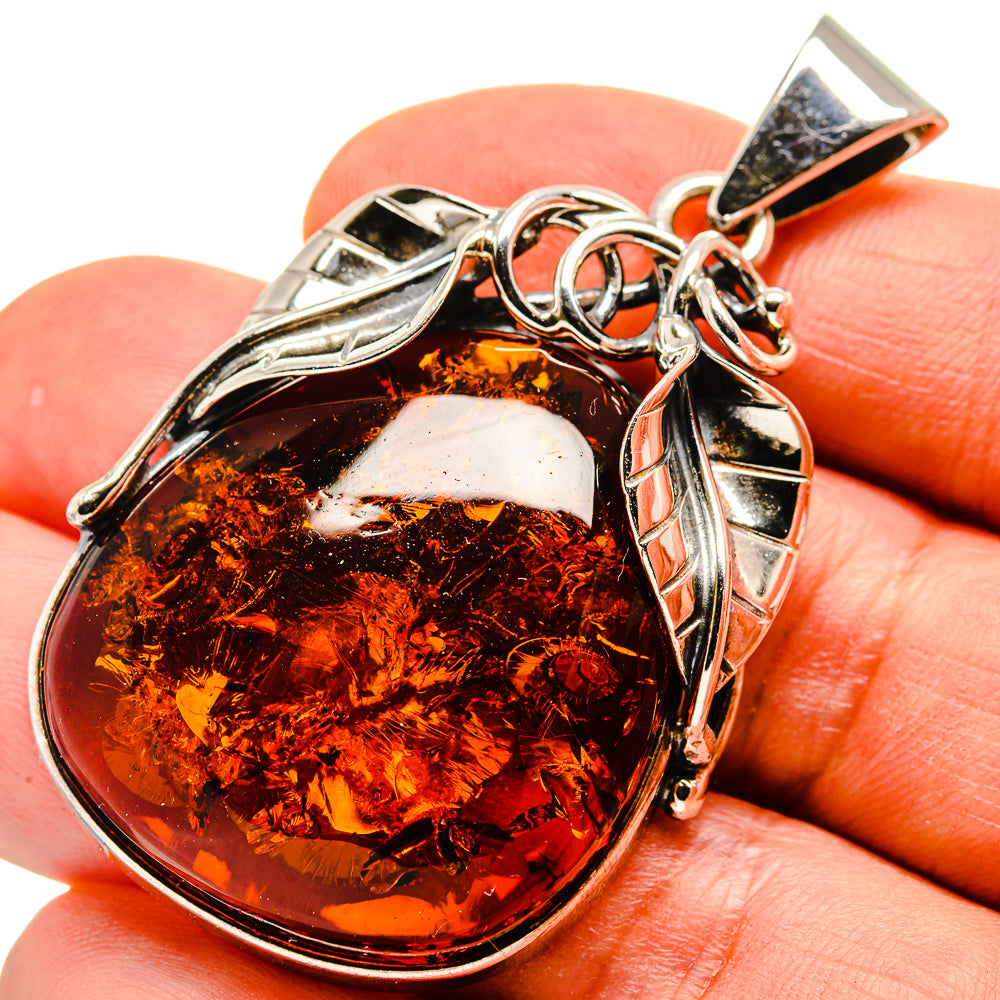 Oval amber pendant in 925 sterling silver with decorative bail and loops