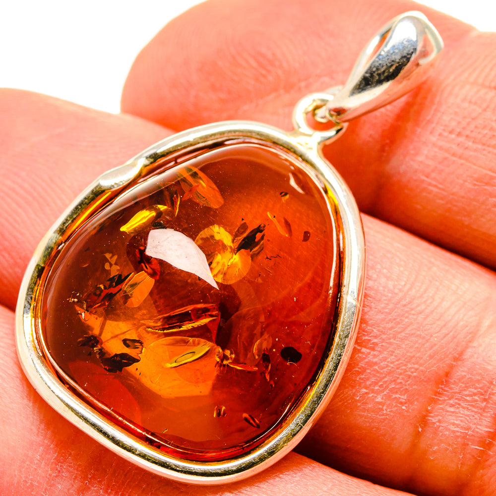 Heart-shaped red amber pendant with 925 sterling silver frame and loop bail