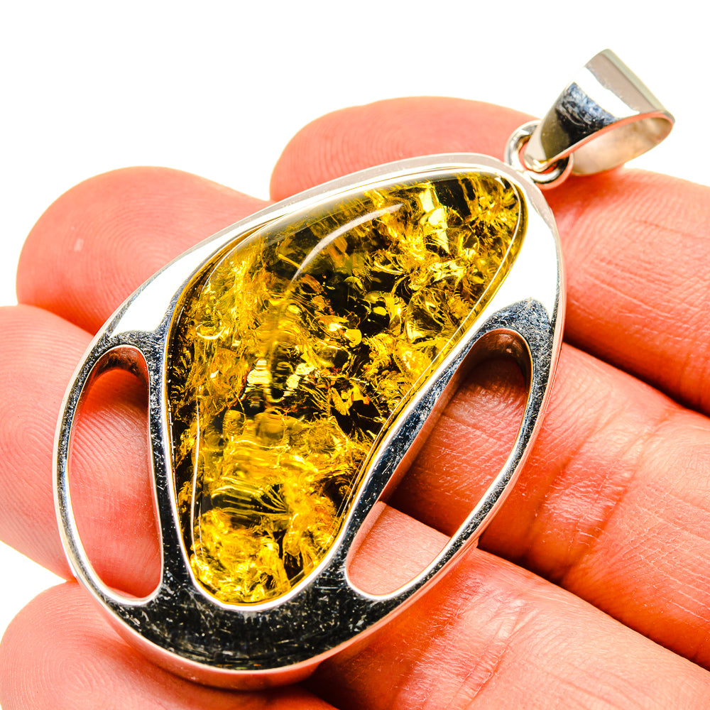 Amber teardrop pendant with oval 925 sterling silver bezel and gold-tone bail