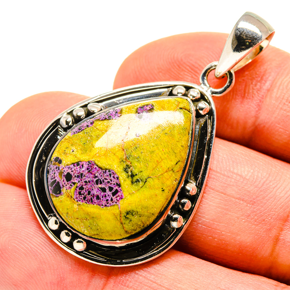 Sterling silver teardrop pendant with yellow and purple gemstone, bail loop at top.