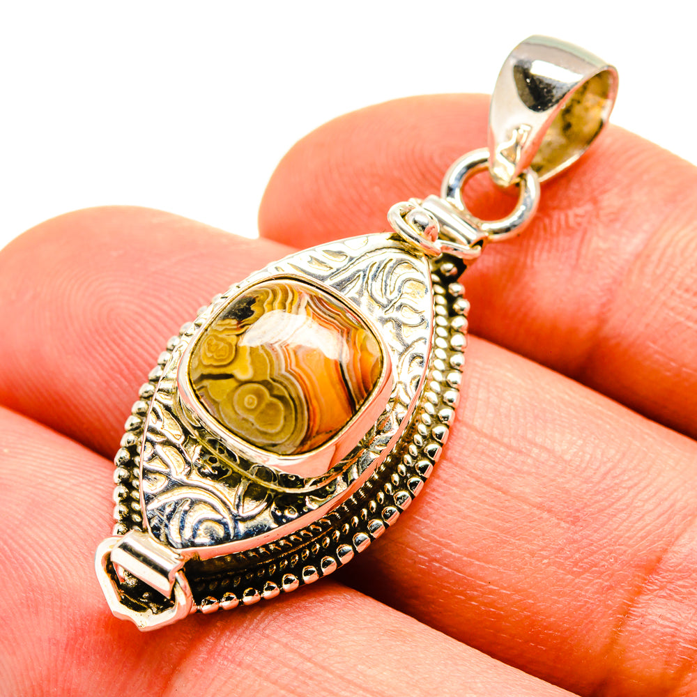Sterling silver pendant with oval orange-brown jasper cabochon, ornate edges, bail