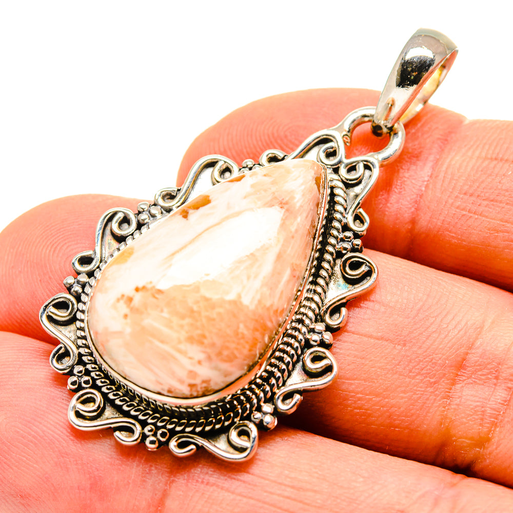 Teardrop gemstone pendant close-up with carved silver filigree and scrolled bail