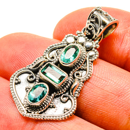 Sterling silver emerald pendant closeup, three bezel-set green stones and decorative filigree