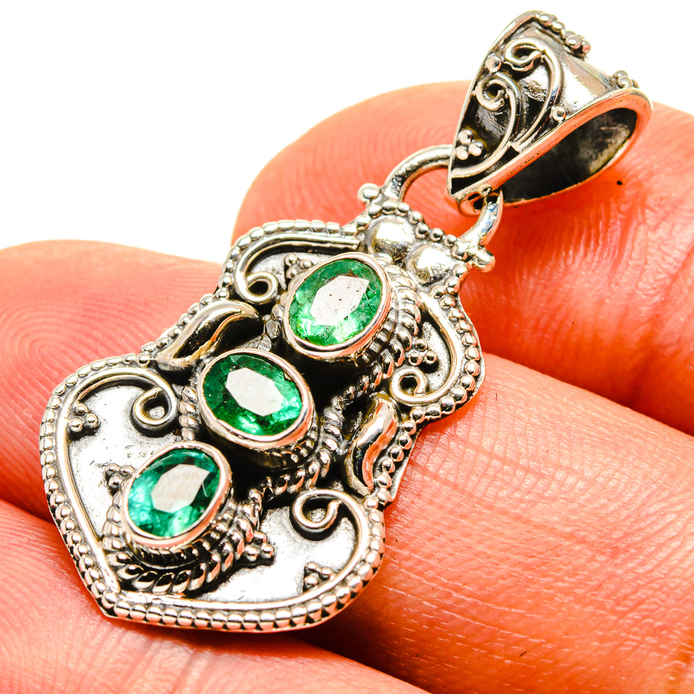 Heart-shaped emerald pendant with three bezel-set green stones in antique silver frame