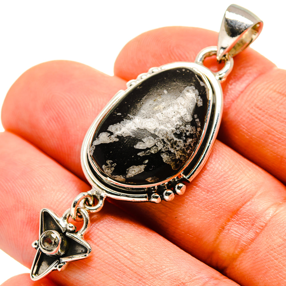 Close-up sterling silver pendant with oval black-and-white stone and dangling star charm