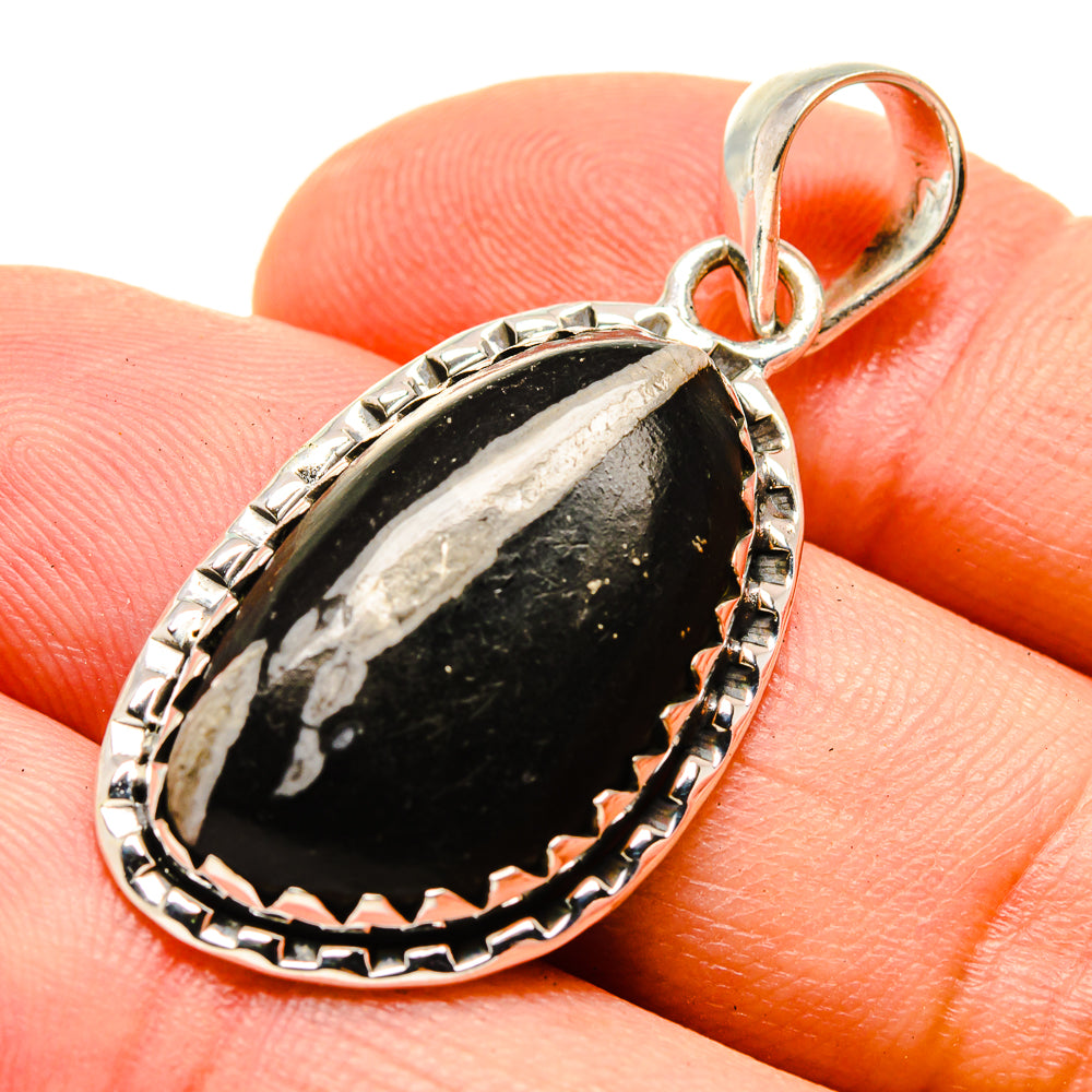 Sterling silver oval stone pendant with orange-red cabochon bail, black center