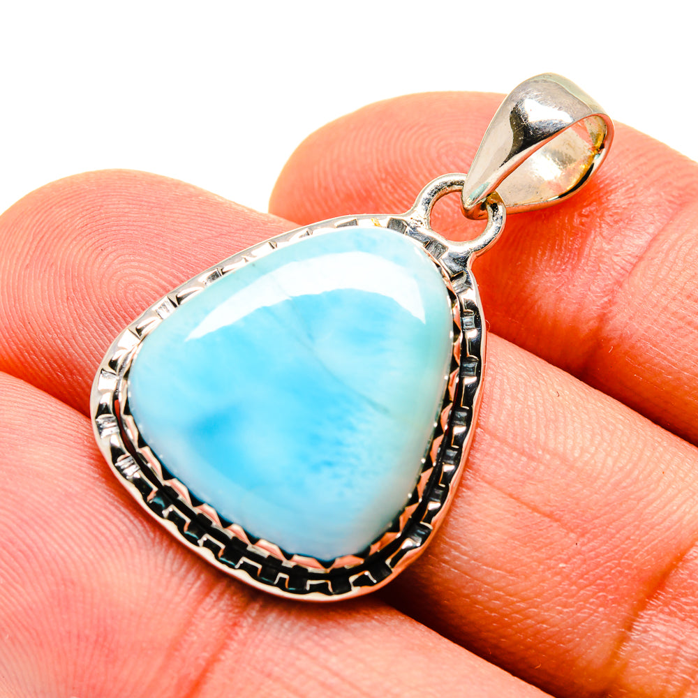 Larimar pendant close-up with blue teardrop stone, textured silver bezel and bail.