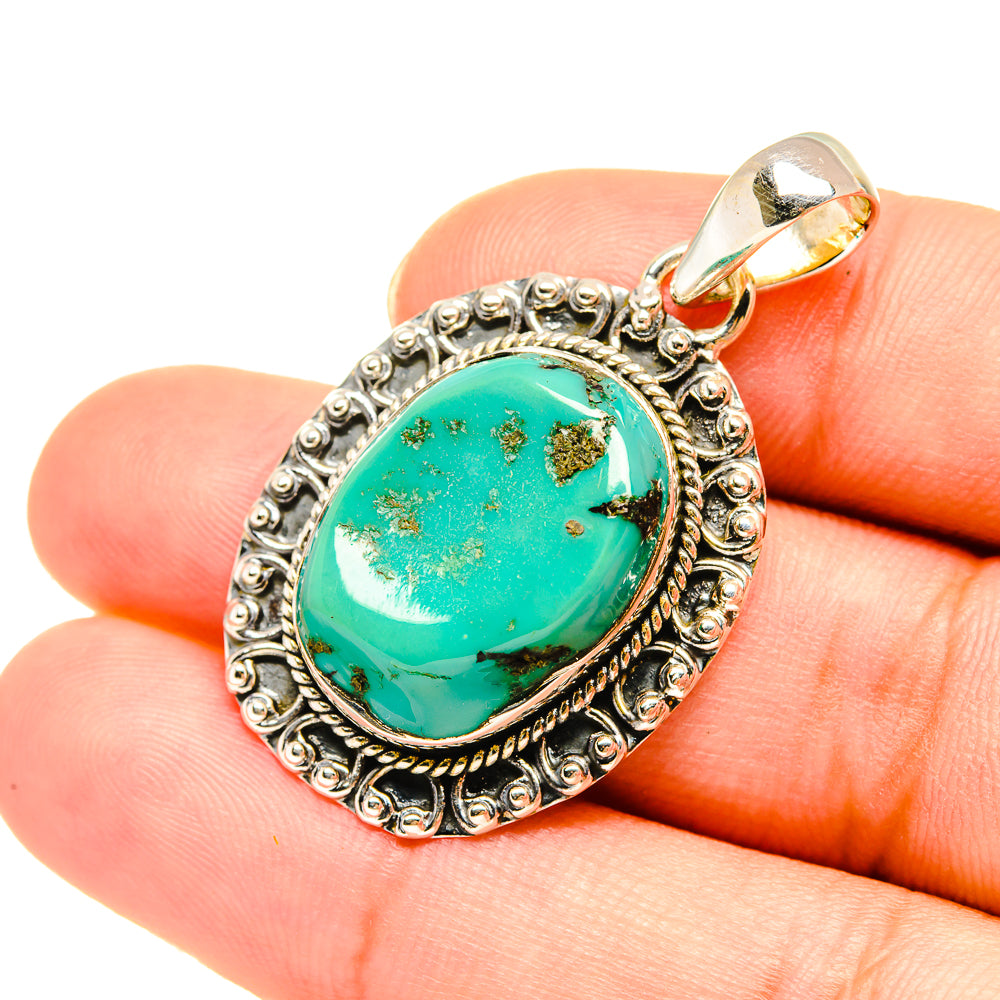Turquoise pendant with oval cabochon, bail ring, and engraved sterling silver frame