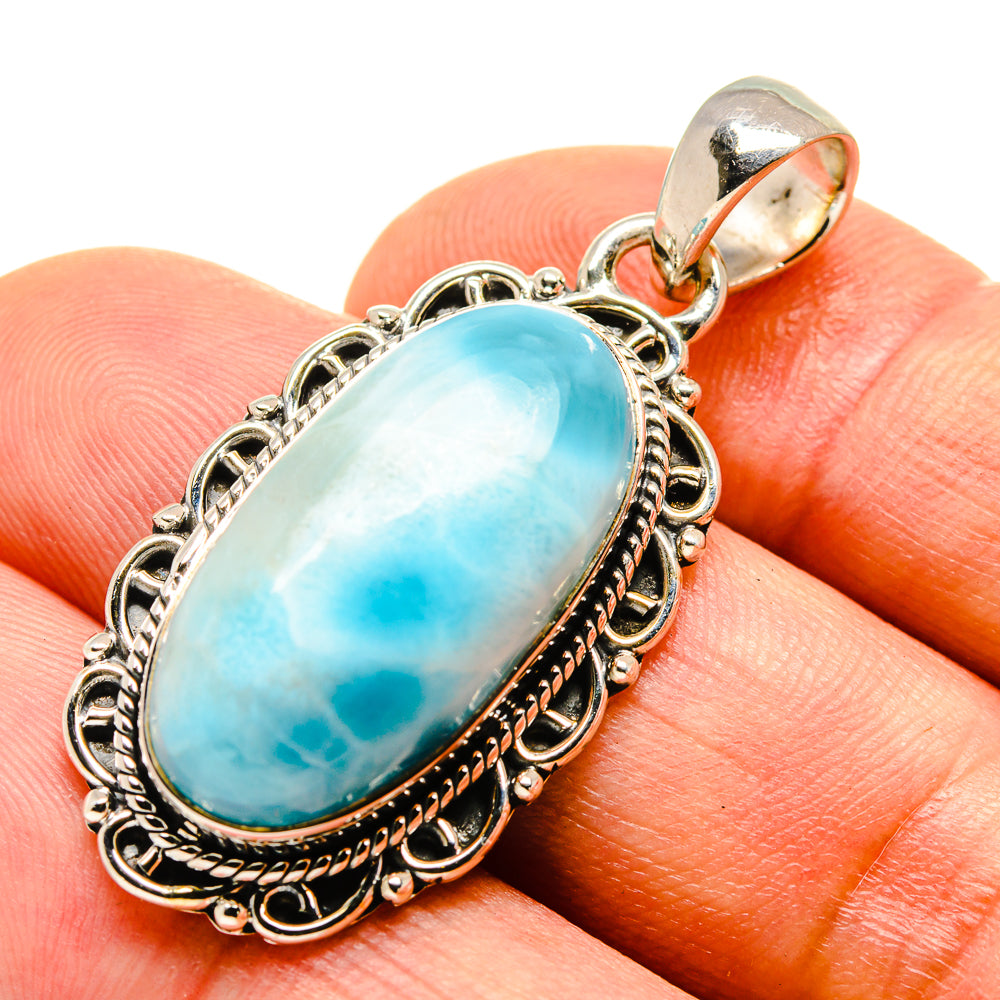 Oval turquoise Larimar pendant close-up on silver bail and detailed bezel setting