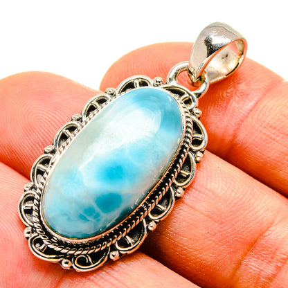 Oval turquoise Larimar pendant close-up on silver bail and detailed bezel setting