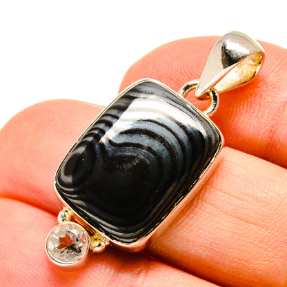 Psilomelane gemstone pendant with silver frame, gold bezel, and two clear accents