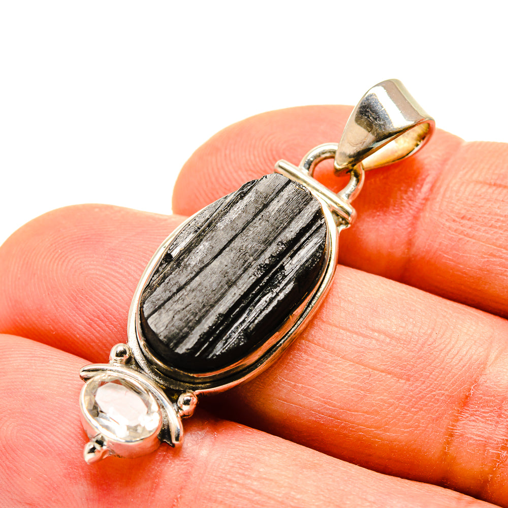 Dark oval stone pendant with clear round crystal accents in silver-tone setting