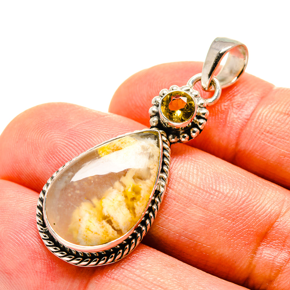 Sterling silver pendant with yellow teardrop stone on finger and round citrine top