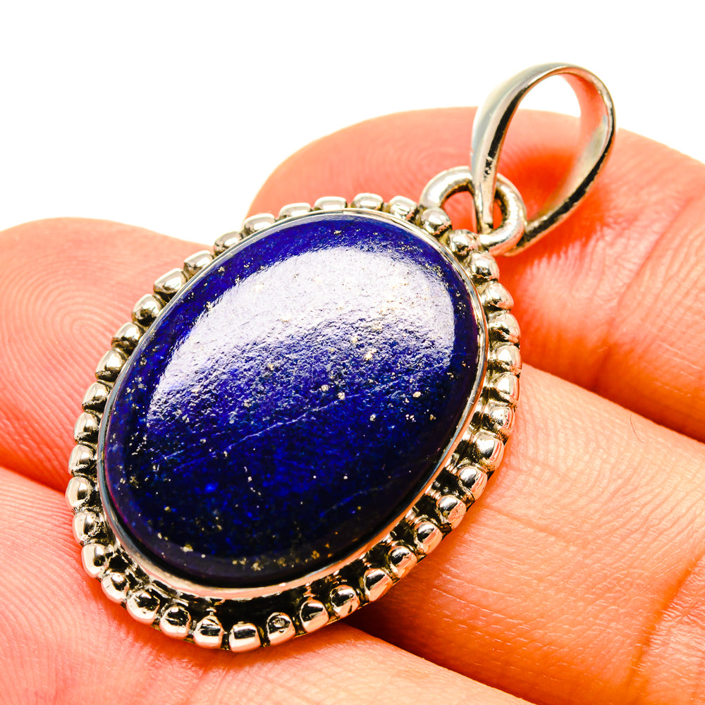 Lapis lazuli pendant close-up with oval blue cabochon and silver bail