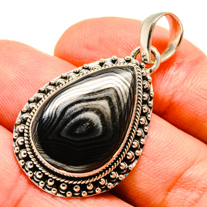 Teardrop silver pendant with black-and-gray banded stone, beaded rim, and loop bail