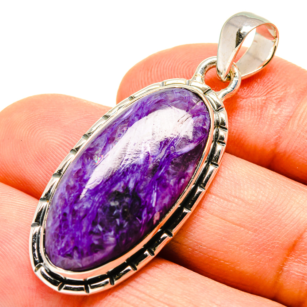 Sterling silver charoite pendant, purple oval cabochon set in oval bezel on fingertip.