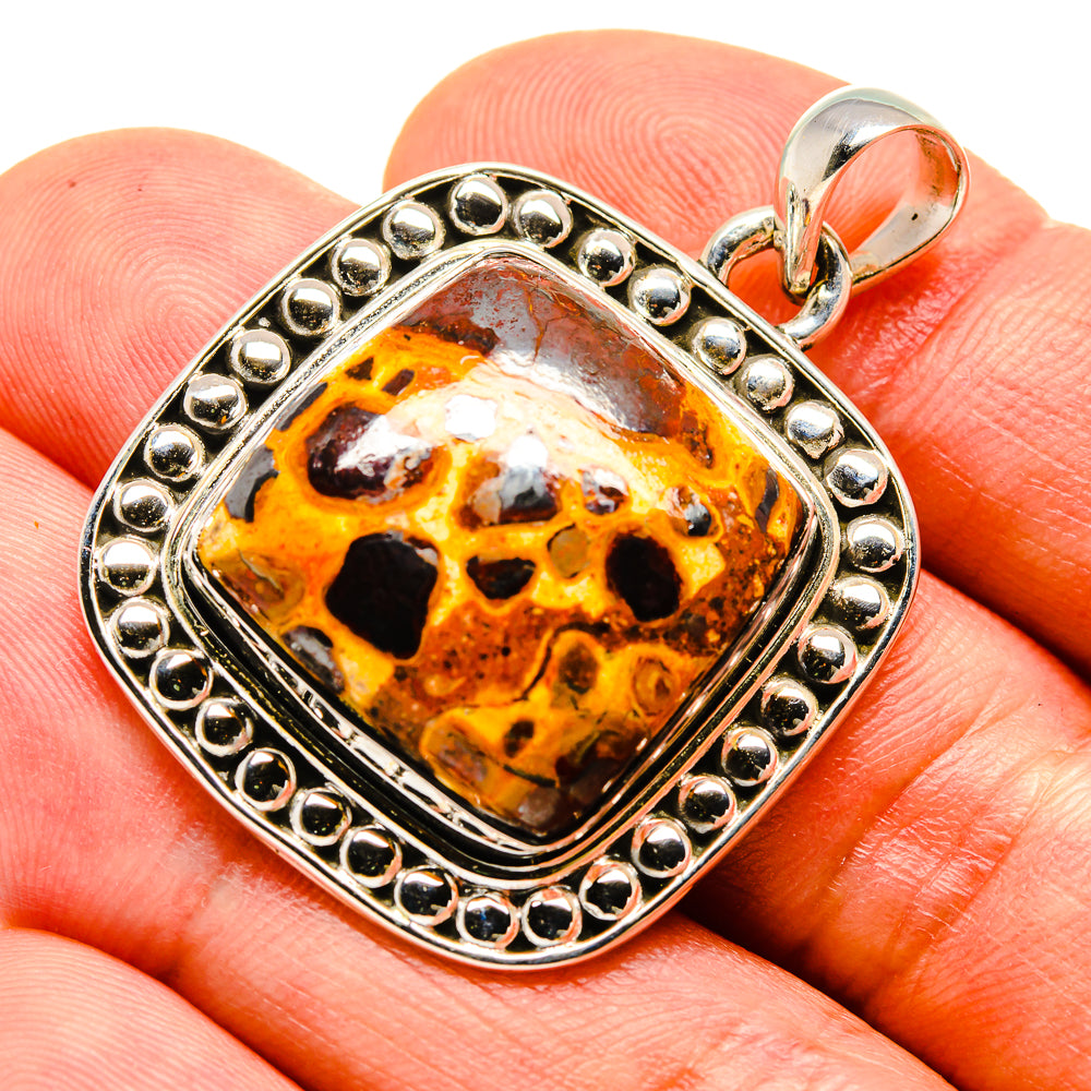 Sterling silver pendant with orange bauxite skull cabochon in beaded frame, bail loop