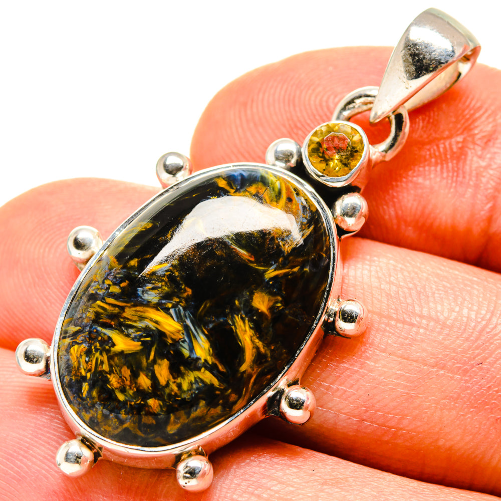 Oval pietersite pendant with citrine stone and round silver prong accents.