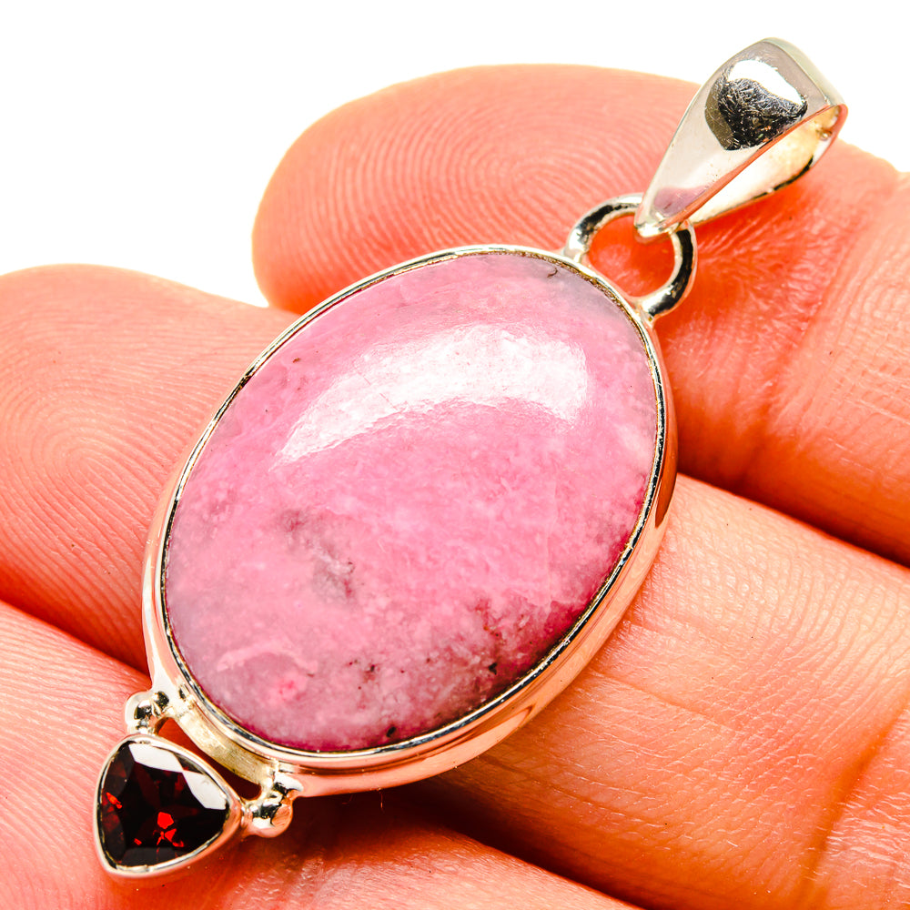 925 sterling silver pendant with oval pink rhodonite and red garnet; close-up on fingers