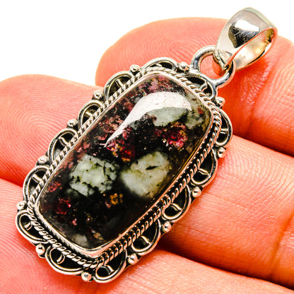 Sterling silver pendant close-up with oval bail and green-red eudialyte cabochon
