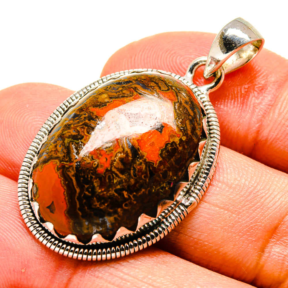 Moroccan agate pendant close-up: oval orange-red and dark agate set in silver frame.