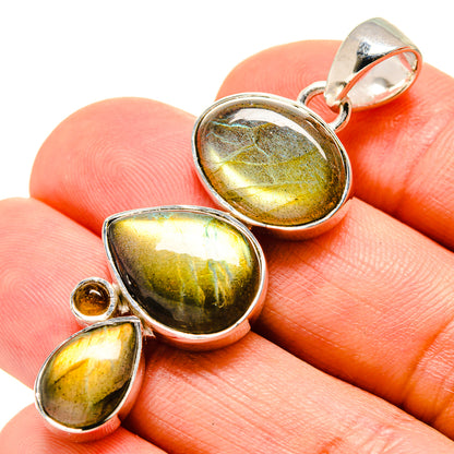 Sterling silver pendant with three oval cabochon gemstones in gold, green, and dark iridescent tones