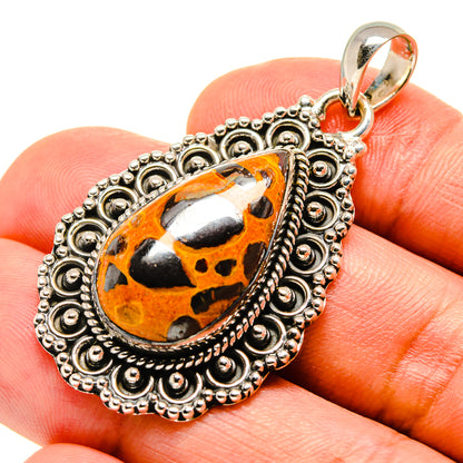 Sterling silver pendant with teardrop orange-black bauxite stone and filigree bezel