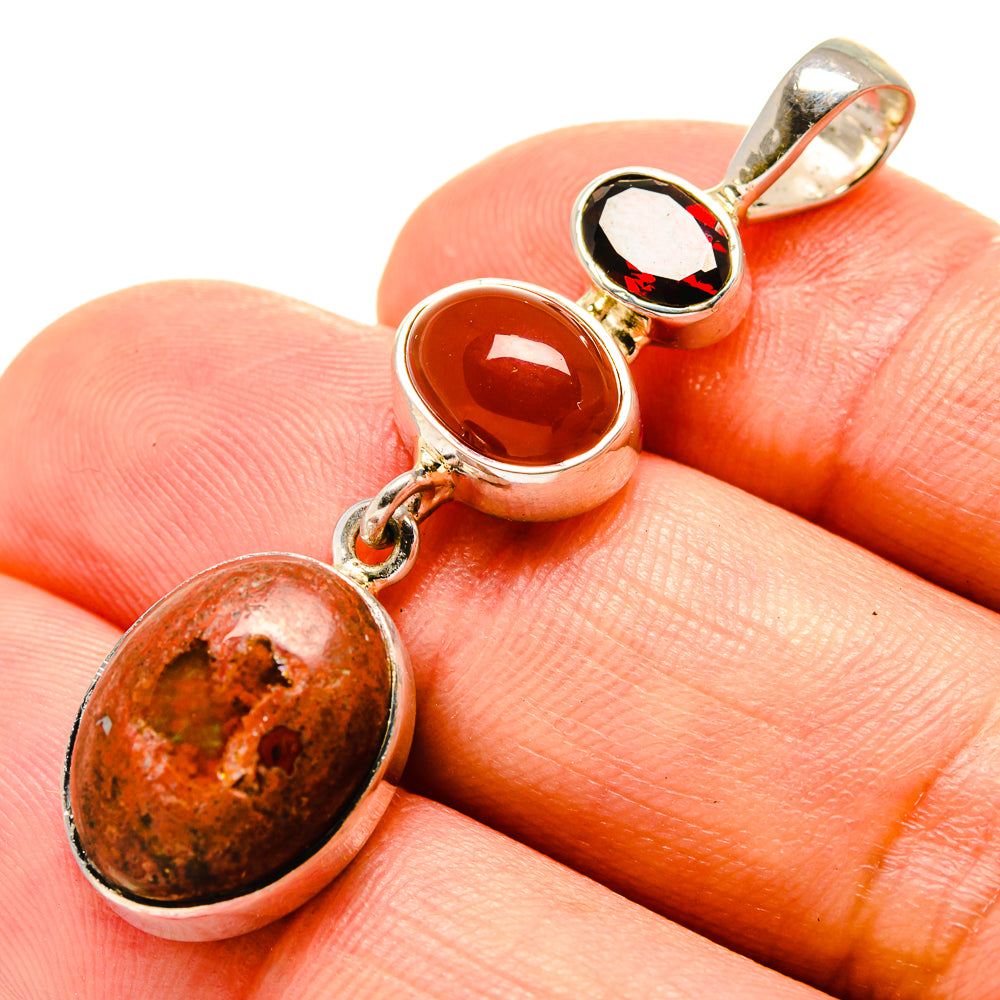 Three-stone oval pendant close-up with red-orange and dark cabochons, 925 silver