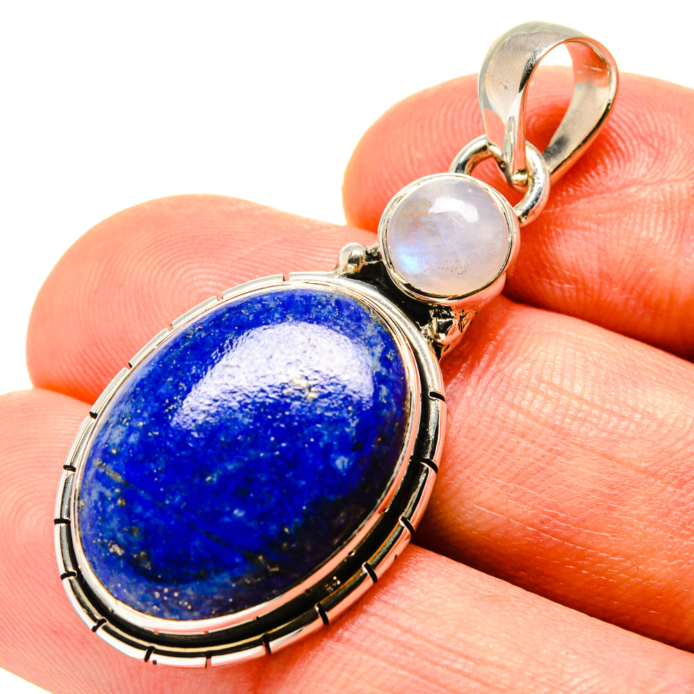 Lapis lazuli oval pendant with silver bezel and two round moonstones, close-up view