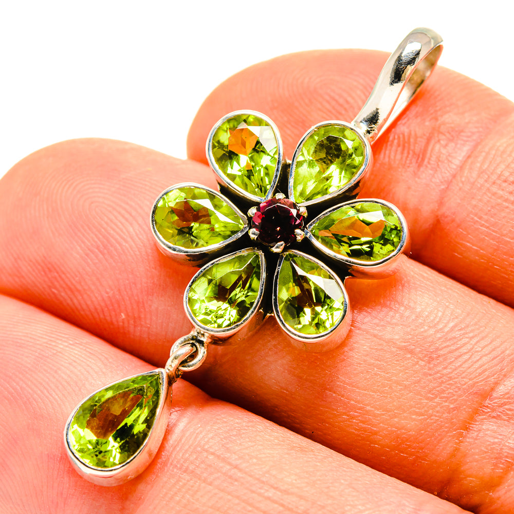 Peridot pendant: sterling silver flower with green teardrop gemstones and dangling drop.