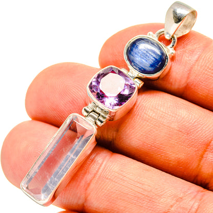 Gemstone pendant with blue cabochon, purple faceted stone, and clear crystal in silver setting