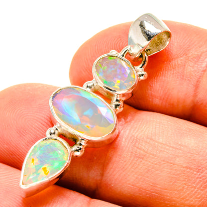 Opal pendant on finger, three oval Ethiopian opals in silver bezel settings with bail
