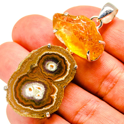 Orange-gold crystal slice pendant in sterling silver setting, shown on fingertip