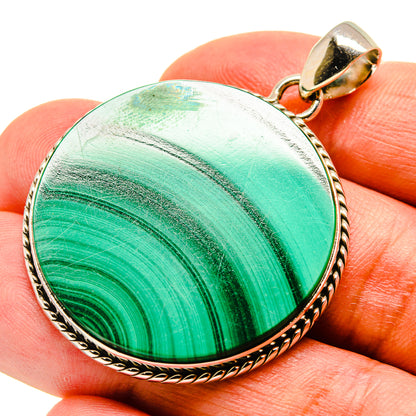 Malachite pendant with round green stone and gold-tone rim, on bail loop