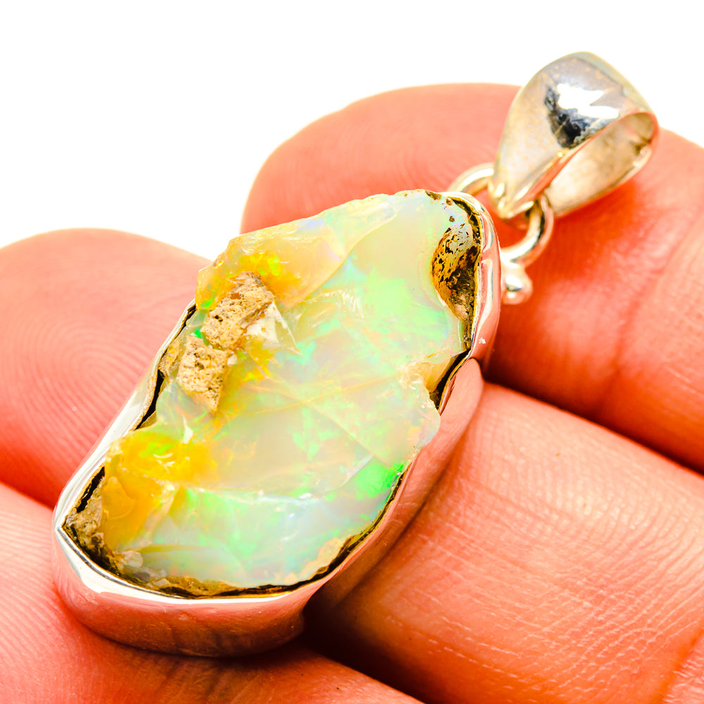 Rough opal pendant in silver-tone and gold-tone bezel, iridescent yellow-green stone
