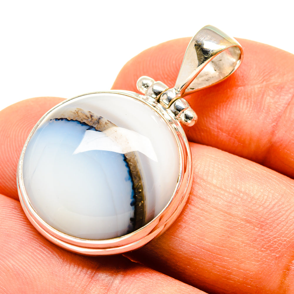 Sterling silver agate pendant with round stone cabochon and bail loop on side.