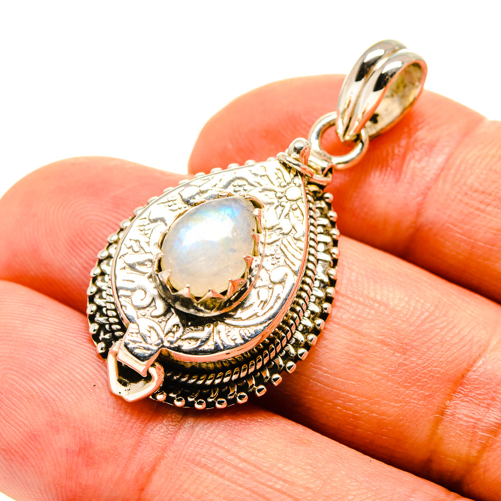 Gold-tone moonstone pendant close-up with oval opalescent stone and detailed silverwork