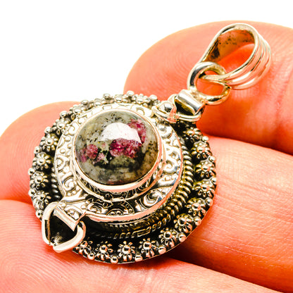 Round gemstone pendant in silver with red-green speckled cabochon and ornate bail