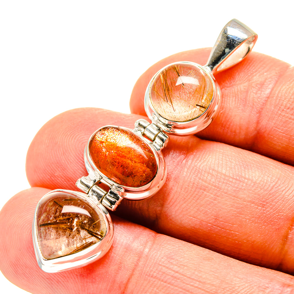 Gemstone pendant close-up with orange sunstone and clear rutilated hearts in silver bezels