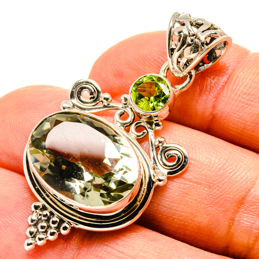 Sterling silver pendant with large oval green faceted stone and small round green accents