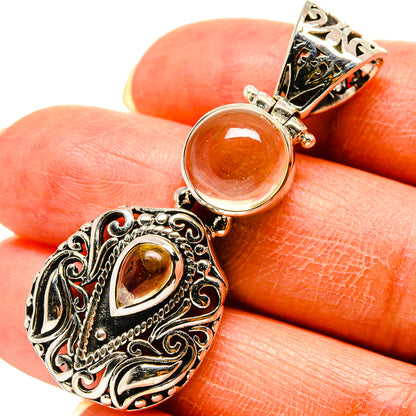 Sterling silver rose quartz pendant with two orange-pink cabochons and ornate frame