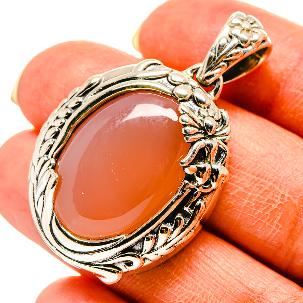 Sterling silver moonstone pendant with peach cabochon and ornate floral frame